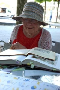 Eine Seniorin liest in historischen Büchern