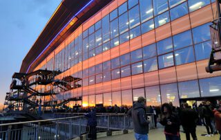 Gläserne Stadtionfassasde des Schalke-Stadions mit Spiegelungen im Sonnenuntergang