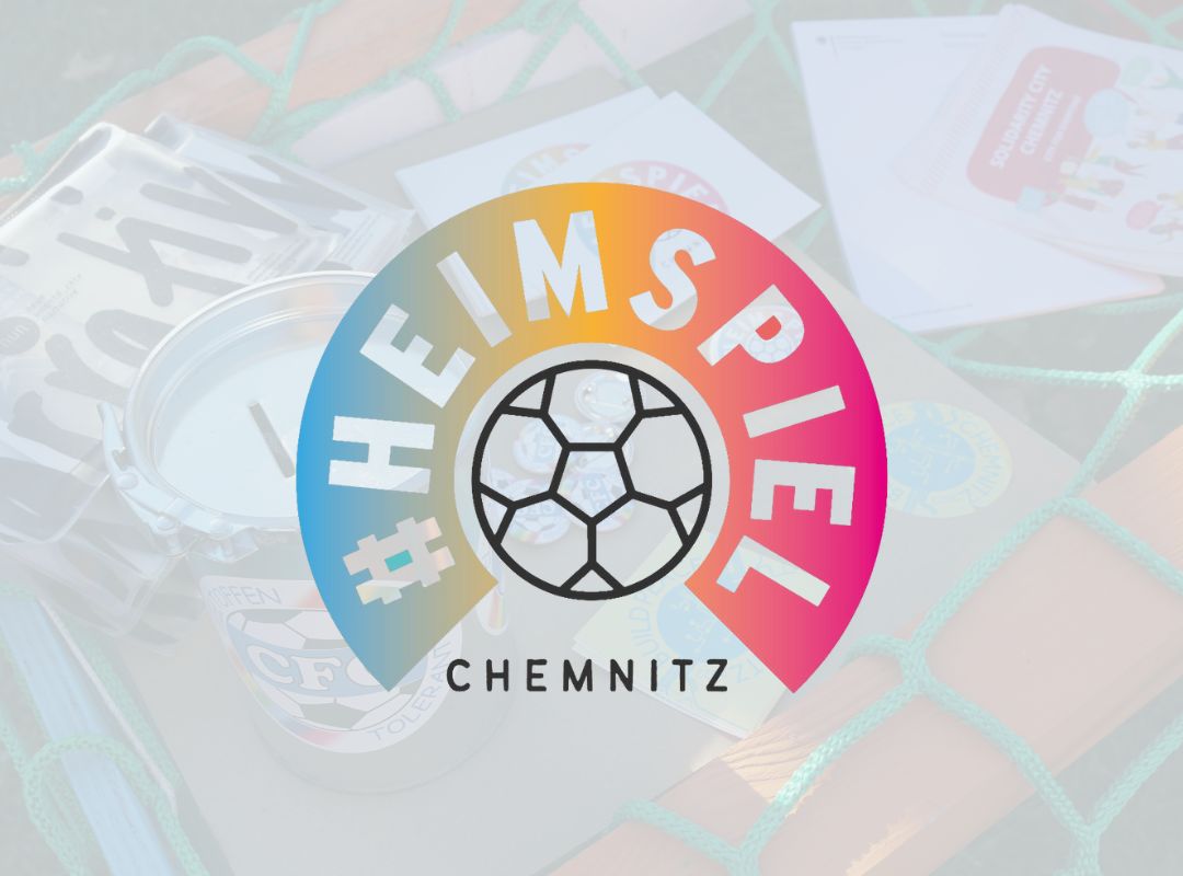 Heimspie-Logo vor einem Foto von nun-Werbematerialien auf einem grünen Netz